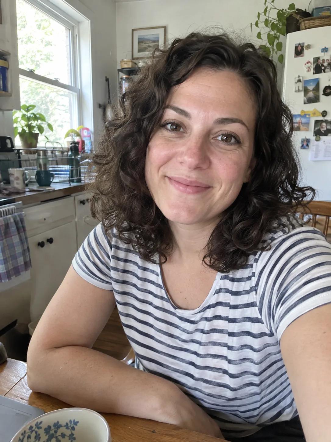 Original photo: a woman with curly hair at a kitchen table