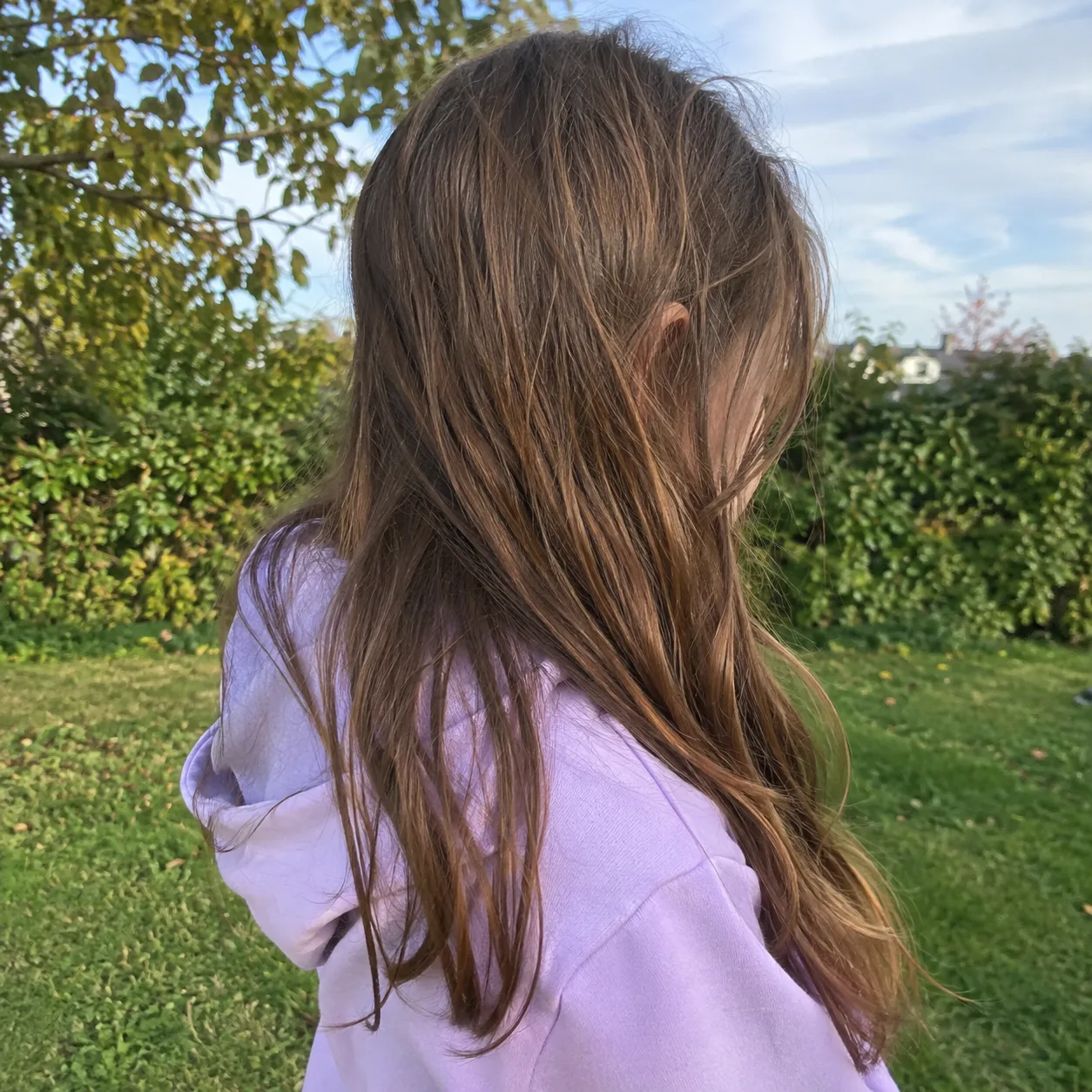 A girl turned away with her face hidden by hair
