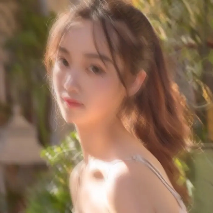 A blurry portrait of a young woman with motion and soft-focus blur, showing unclear facial features and reduced edge details — used as an example for AI portrait deblurring comparison.